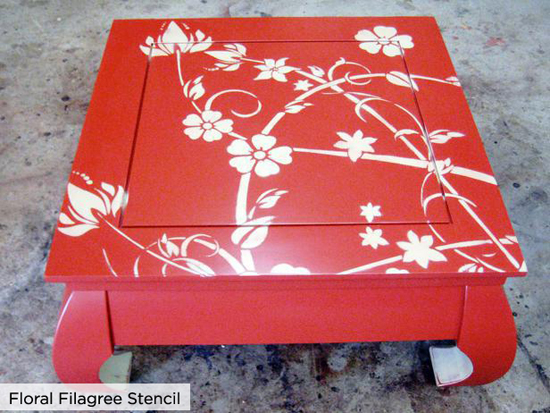The red painted table uses the Cutting Edge STencils Floral Filigree stencil to give an old table new life.