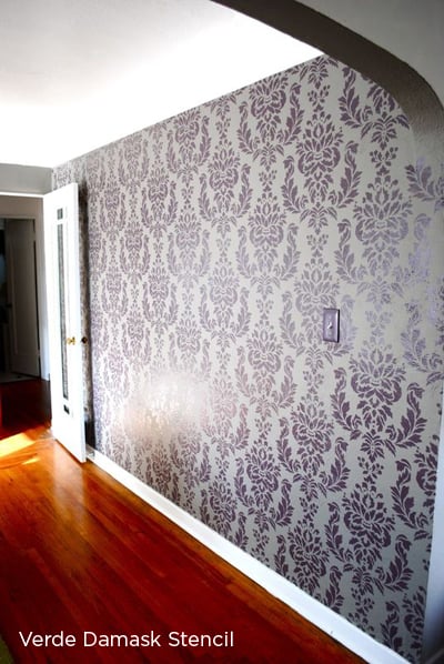A purple stenciled accent wall using the Verde Damask pattern from Cutting Edge Stencils. http://www.cuttingedgestencils.com/damask-stencil-wallpaper.html