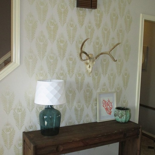 A gold Peacock Feather Allover stenciled accent wall. http://www.cuttingedgestencils.com/peacock-feather-wall-stencil-pattern.html