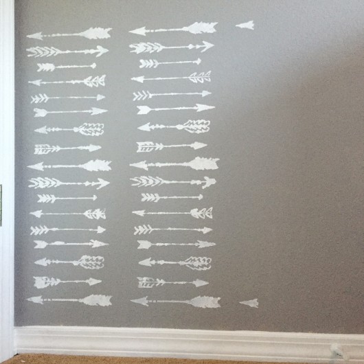 Stenciling a DIY accent wall in a nursery using the Indian Arrows Allover Stencil. http://www.cuttingedgestencils.com/indian-arrows-stencil-pattern-for-walls.html