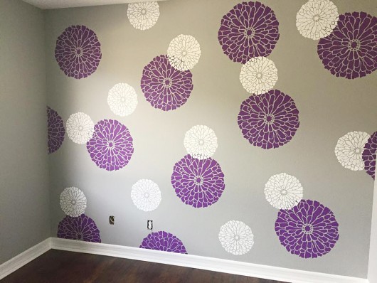 A DIY stenciled nursery accent wall in purple, gray, and white using the Summer Blossoms Flower Stencils from Cutting Edge STencils. http://www.cuttingedgestencils.com/flower-stencils-summer-blossom-floral-wall-stencil-design.html