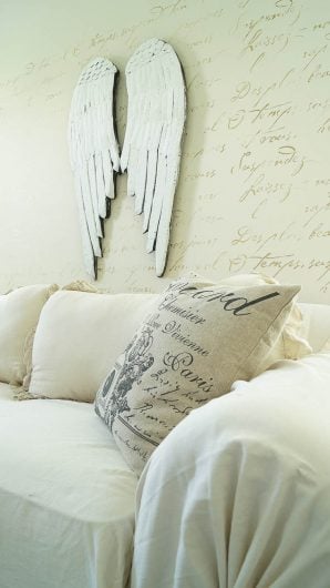 A DIY white and gold stenciled living room accent wall using the French Poem Allover Stencil from Cutting Edge Stencils. http://www.cuttingedgestencils.com/french-poem-typography-letter-stencil.html