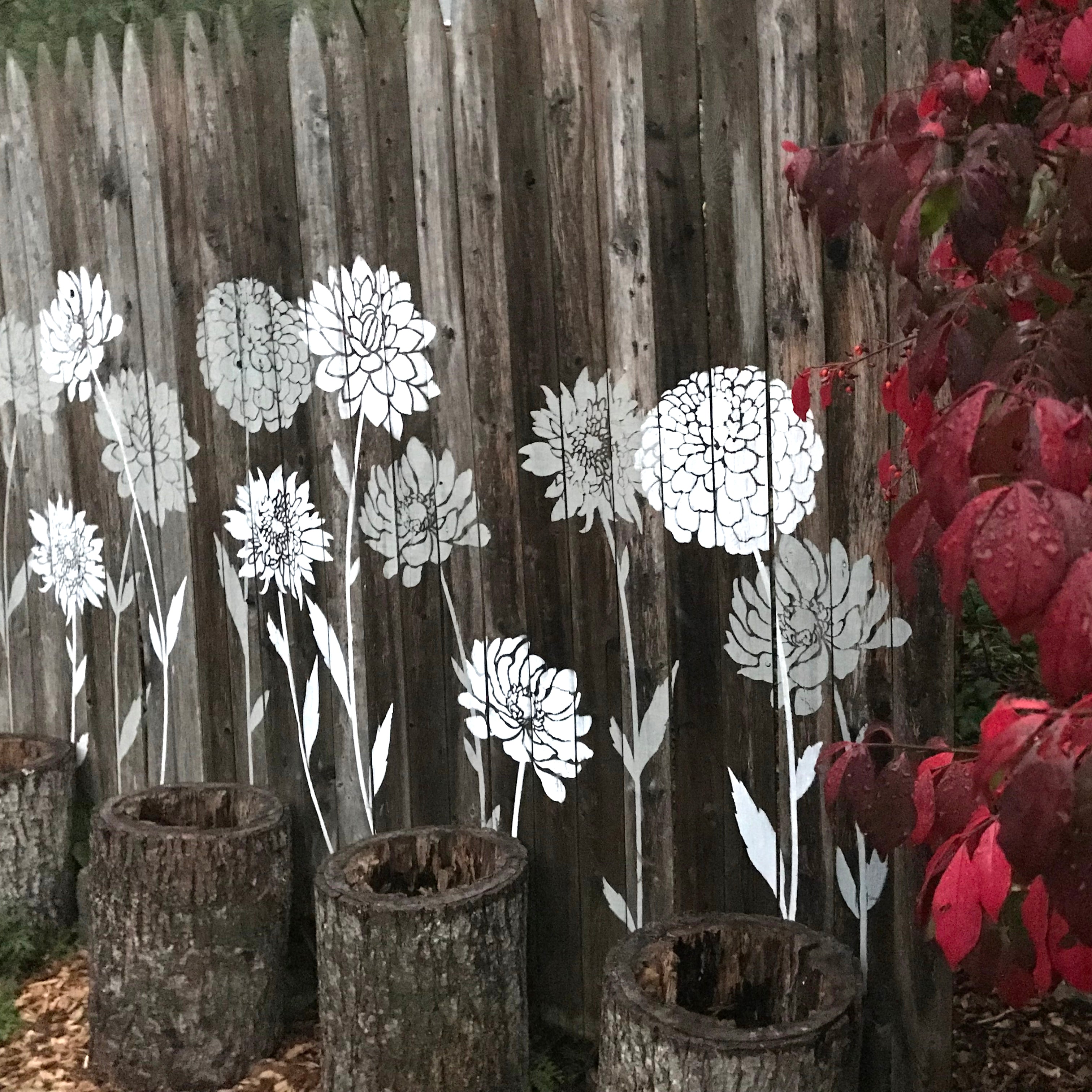 Flower stencils on a wooden fence mural