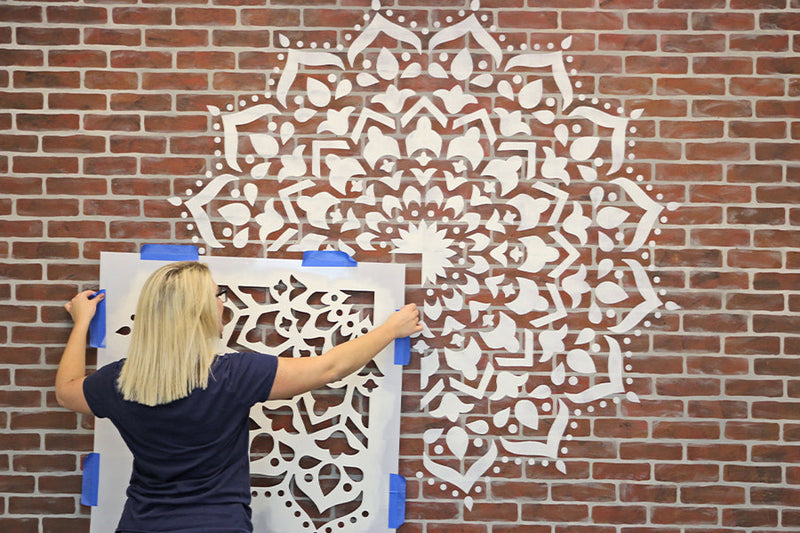 large mandala stencil on brick wall