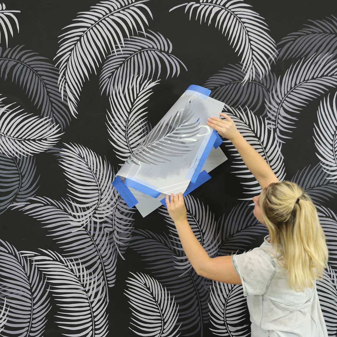 Palm frond stencils on a black wall