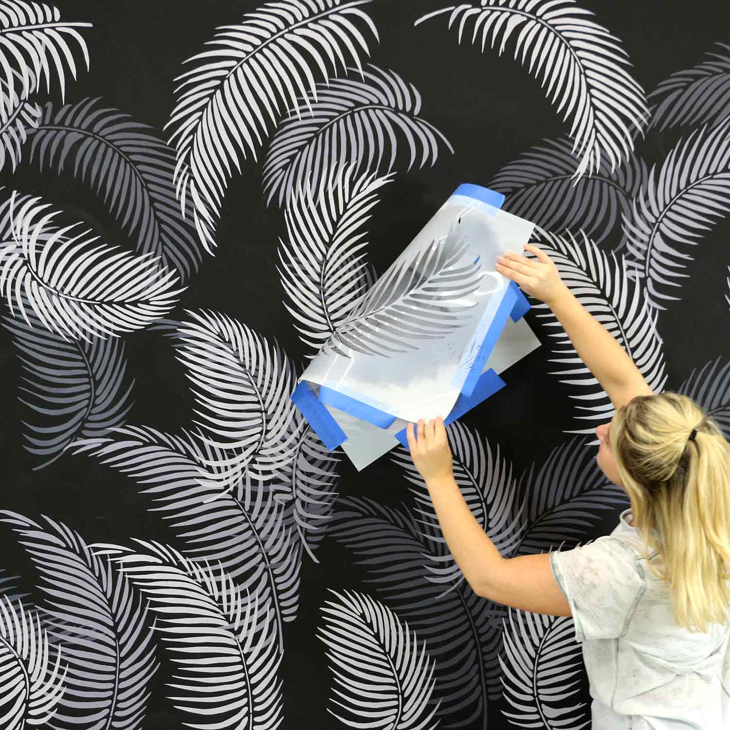 Palm frond stencils on dark wall