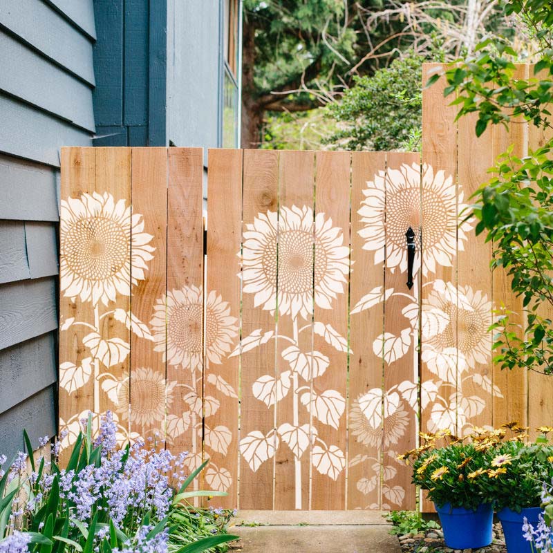 Large sunflowers stenciled on a fence